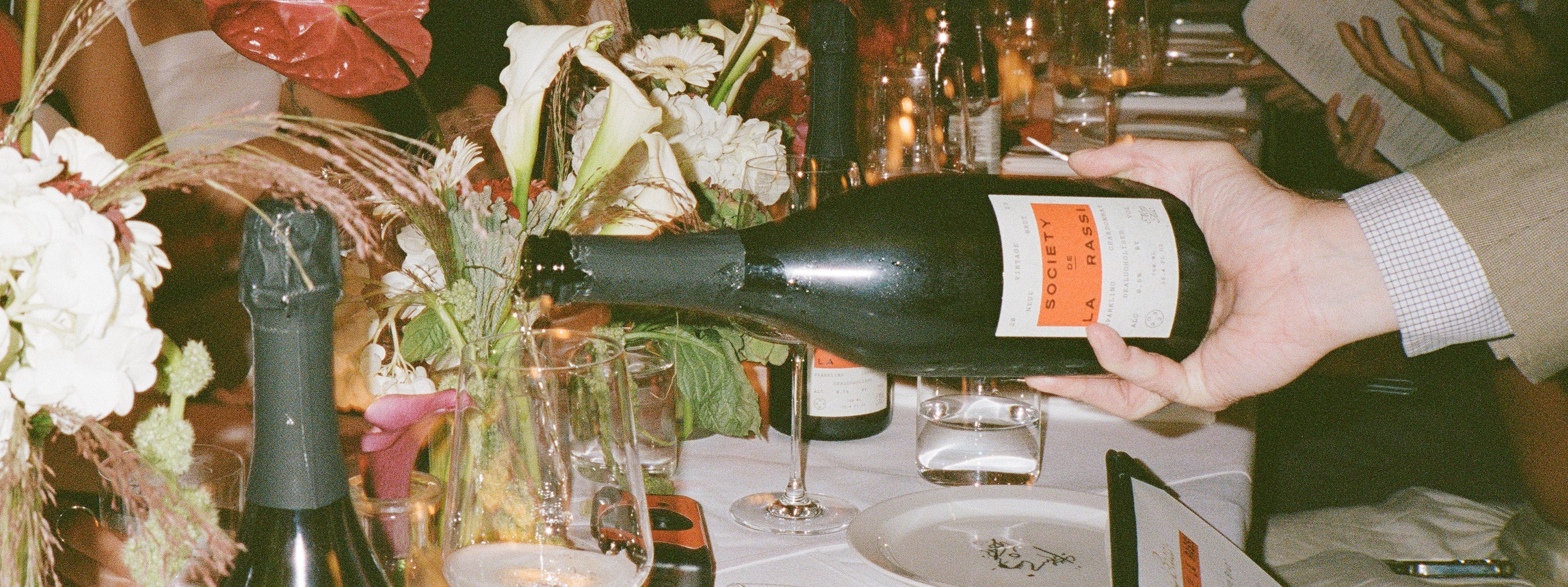 close up of hand pouring na wine into glass at a restaurant