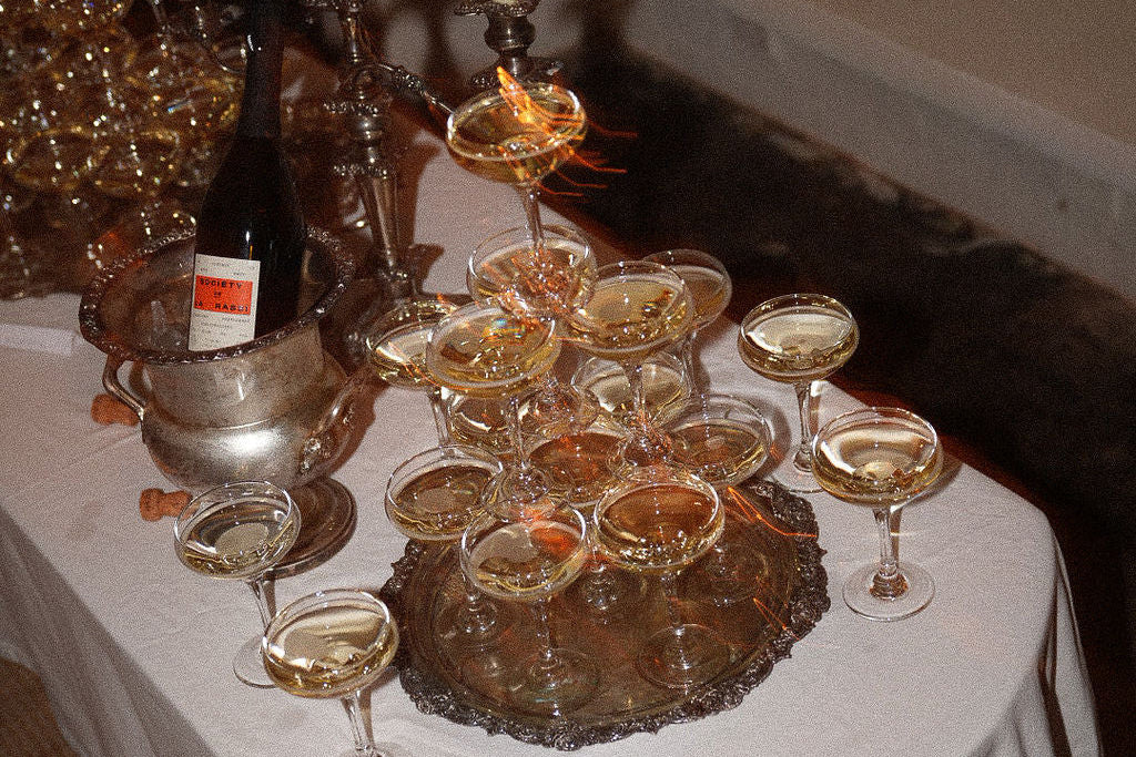 Decorative table setting with wine glasses and candles on a white tablecloth.