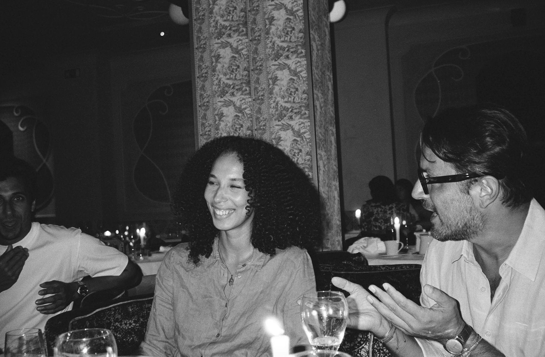 black and white image of people conversing at restaurant table