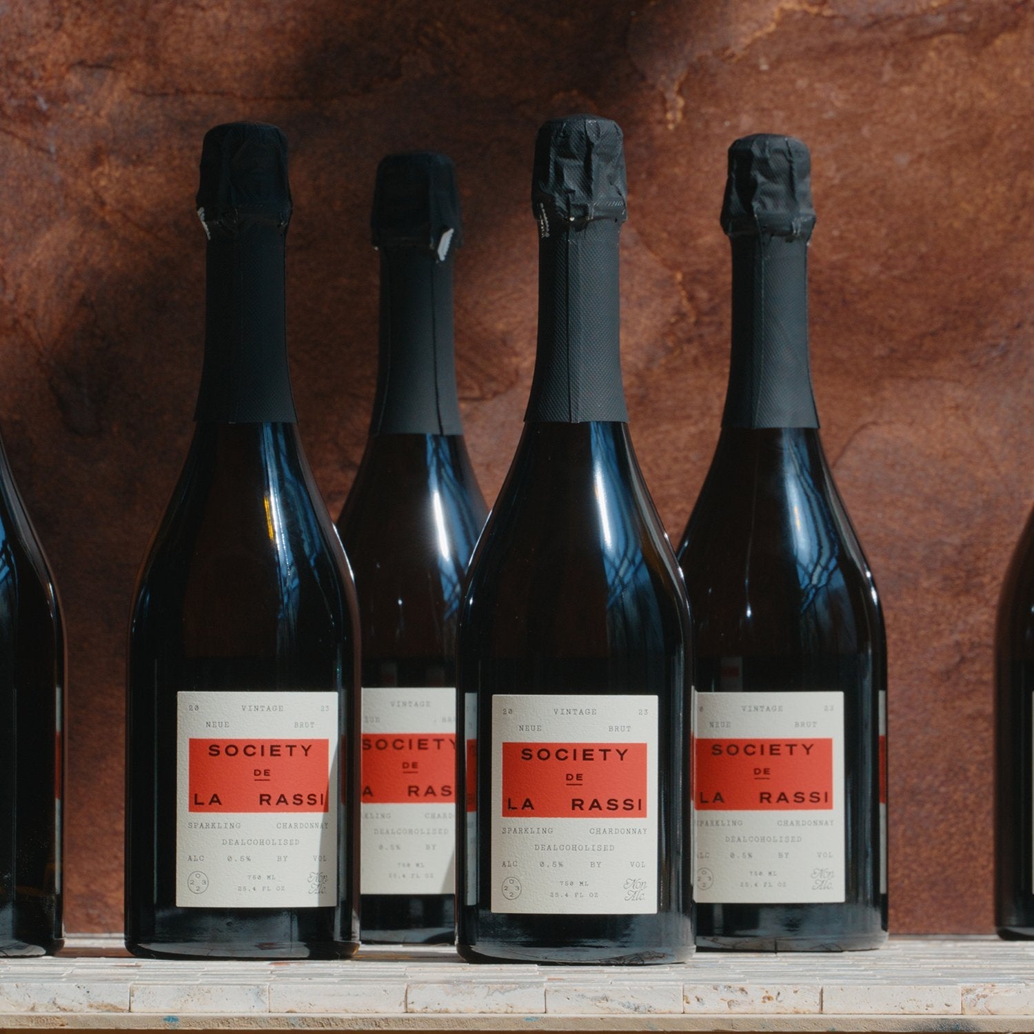Neue Brut Vintage 2023 (Case of 6) sitting next to each other in front of red stone backsplash