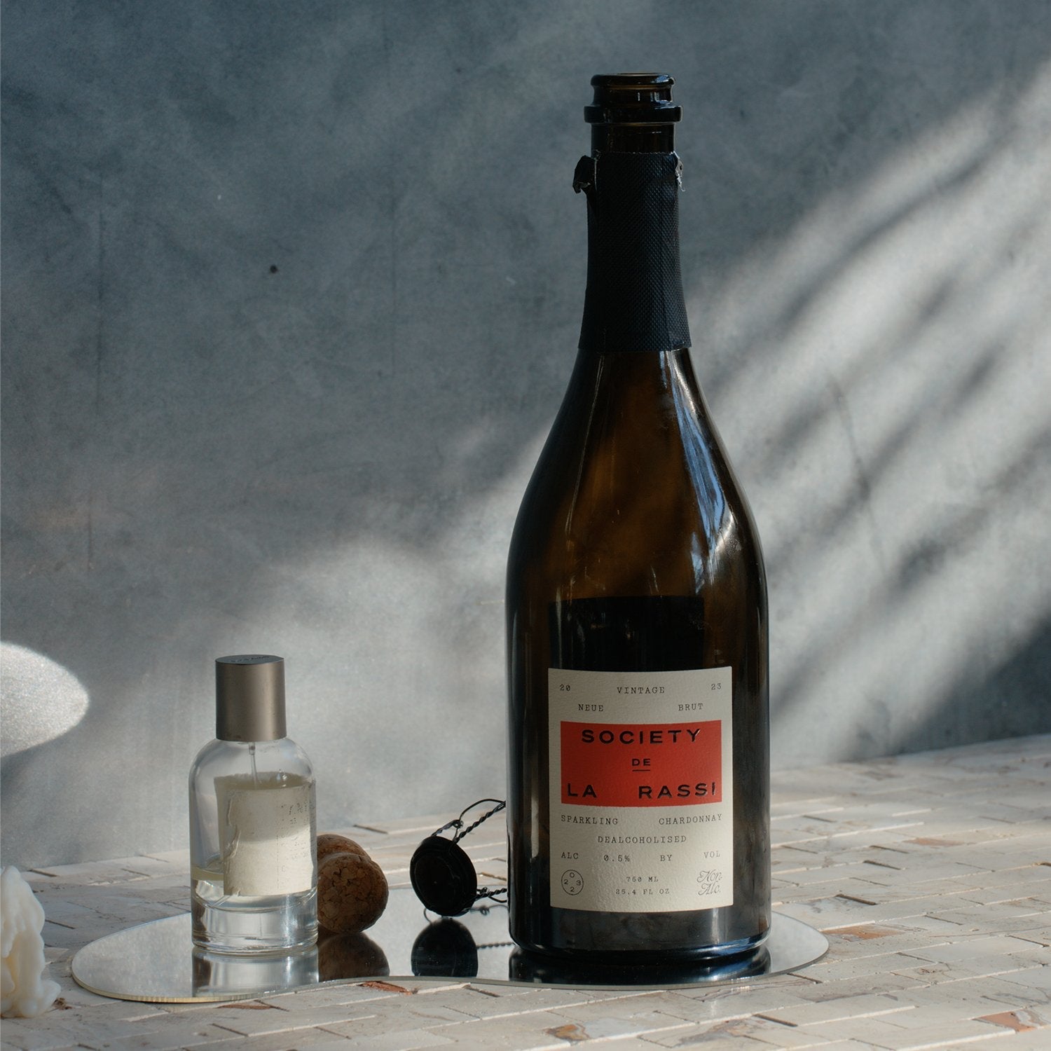 Society De La Rassi Gift Card - Society De La Rassi bottle on mirror with a perfume bottle