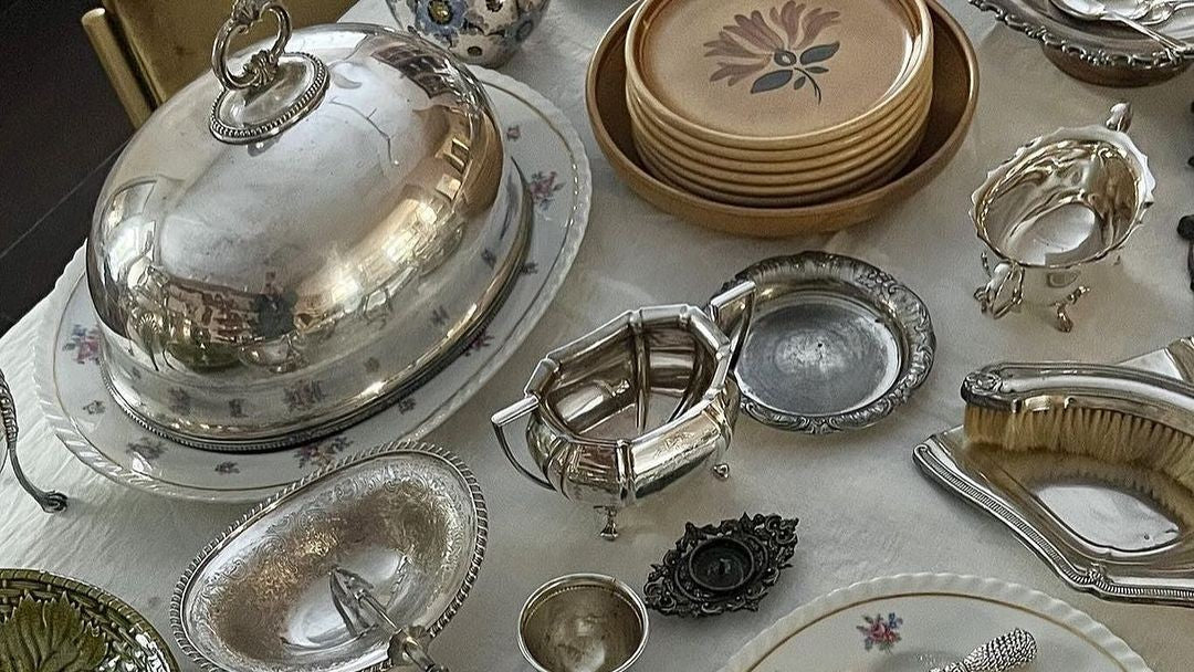 Fancy silver hosting platters and utensils spread out on a table