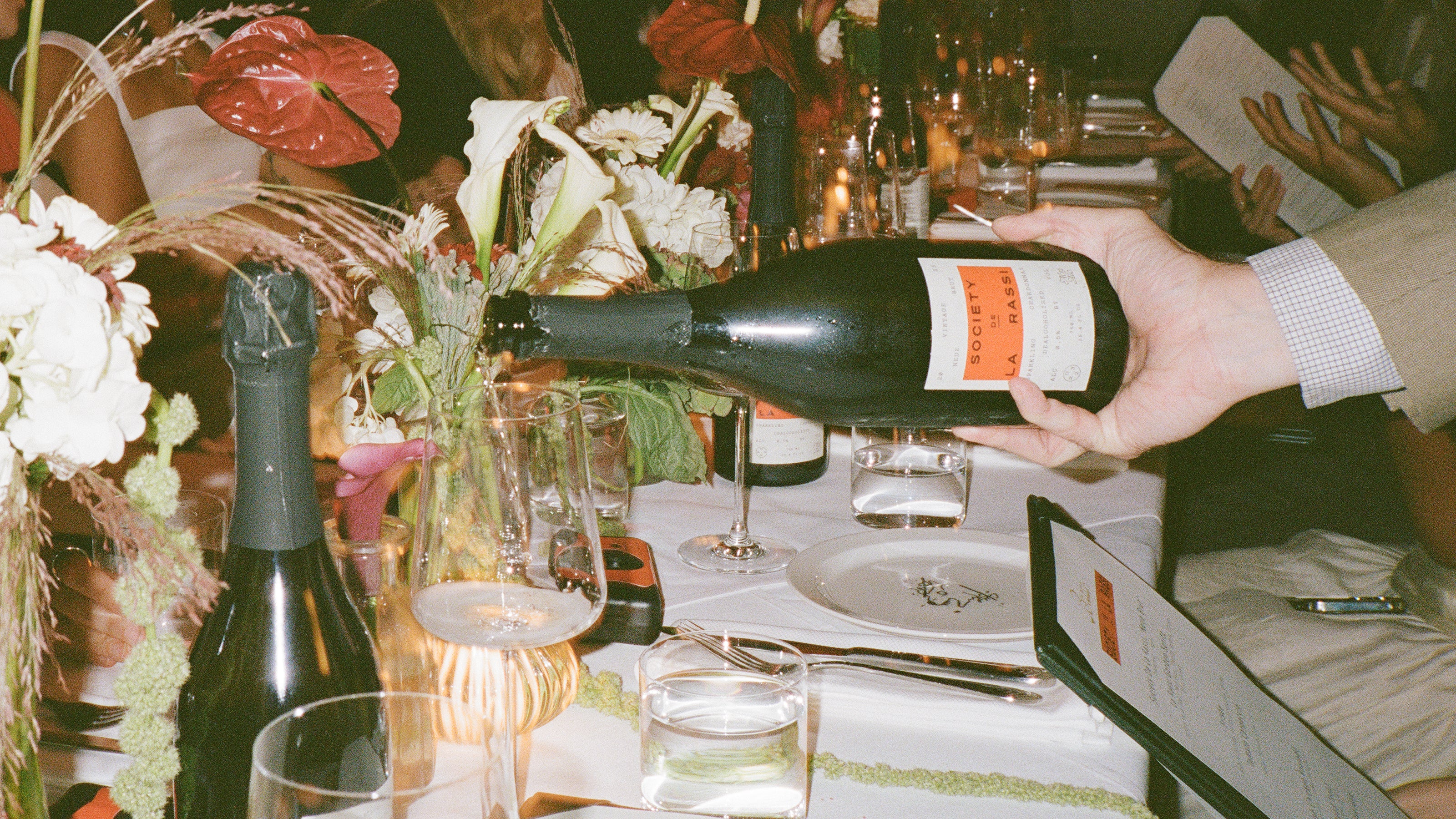 close up of hand pouring na wine into glass at a restaurant 