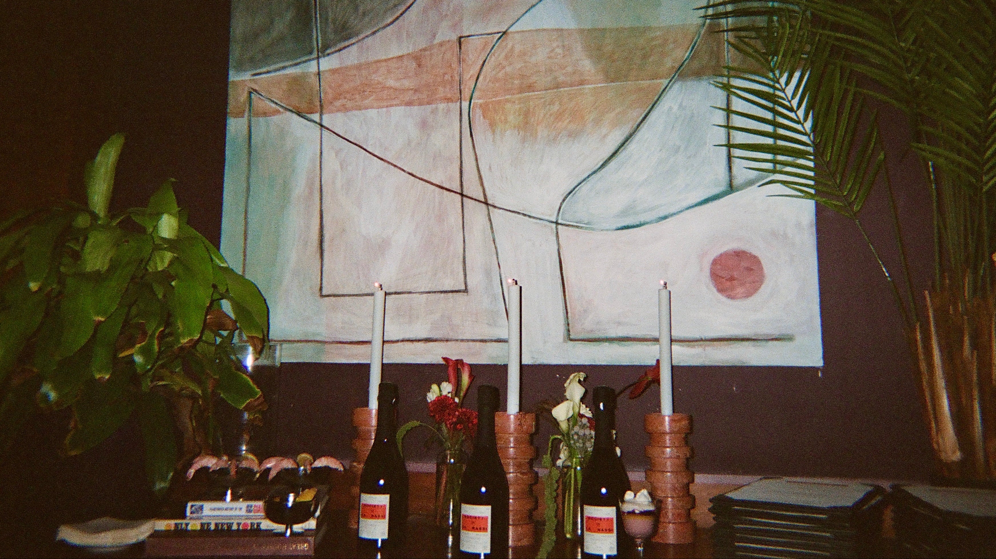 Bottles on a table with abstract art in the background