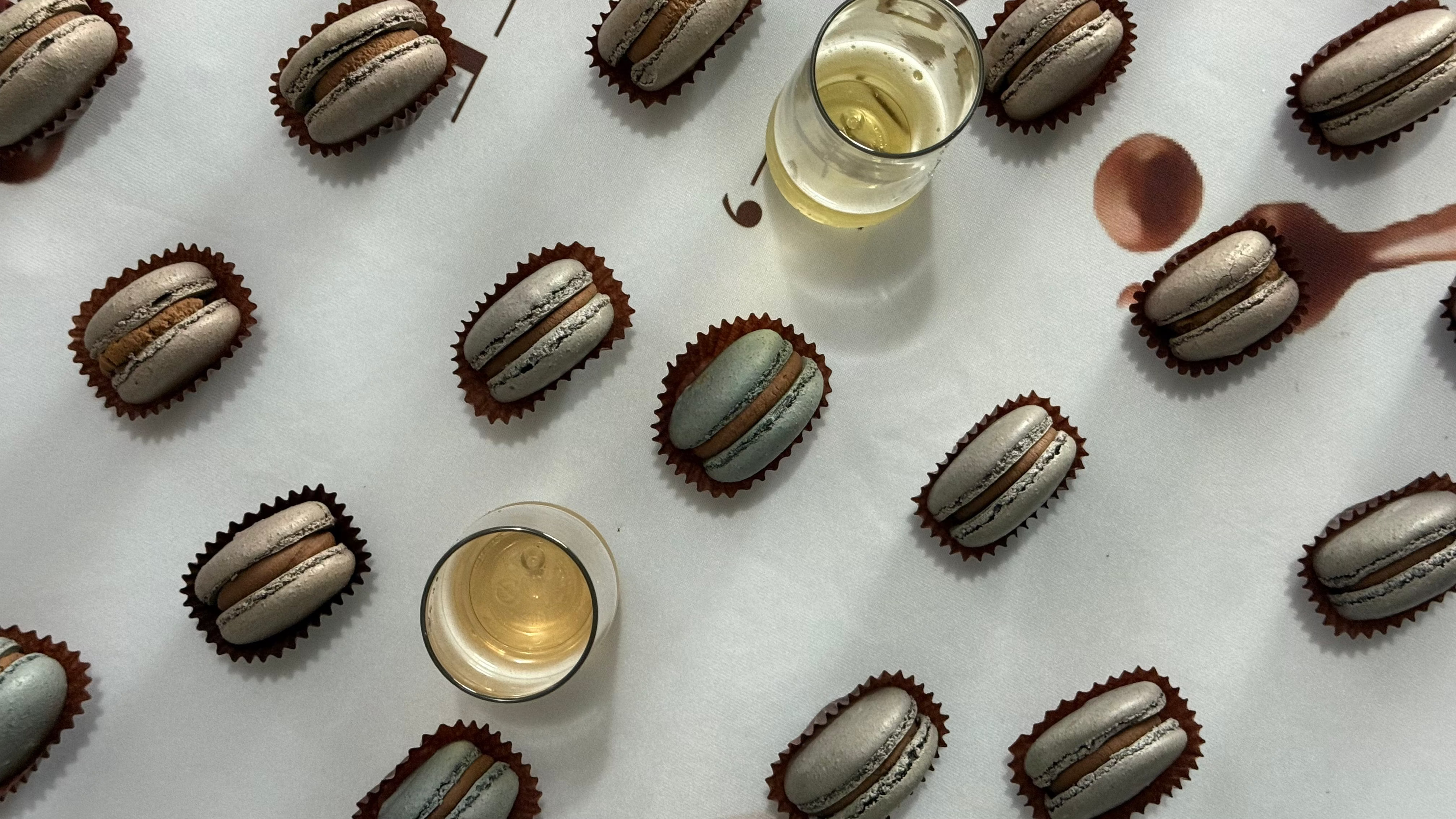 cups on sparkling NA wine and macarons on a table.