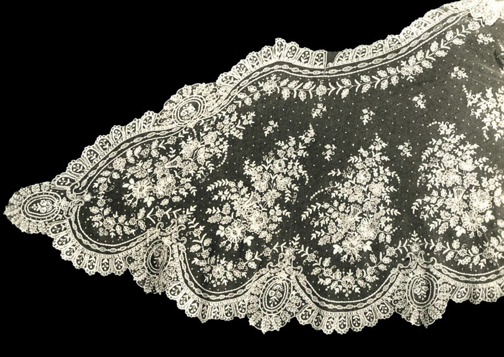 Decorative lace fabric with intricate patterns on a black background