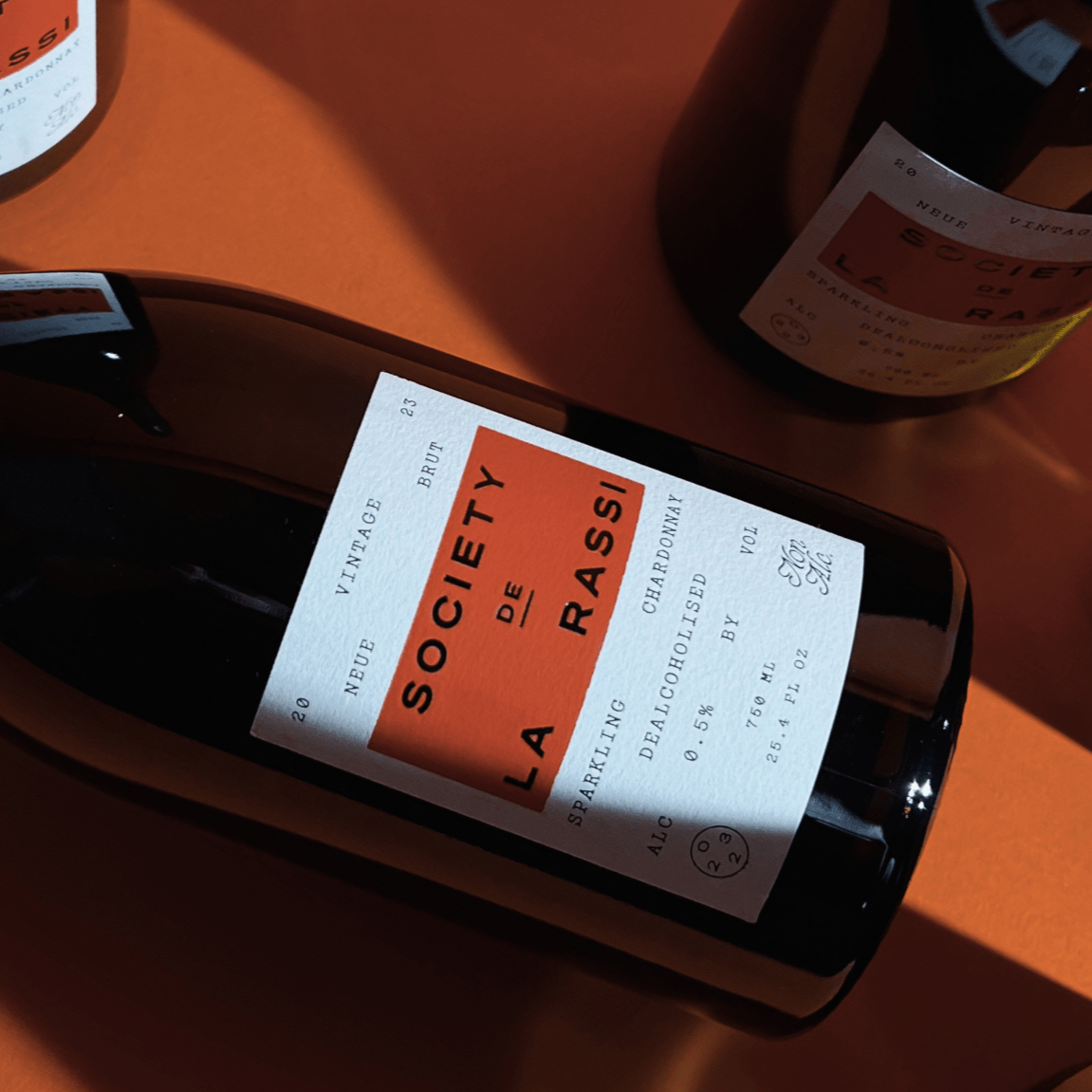 Society De La Rassi Bottles of wine on red background